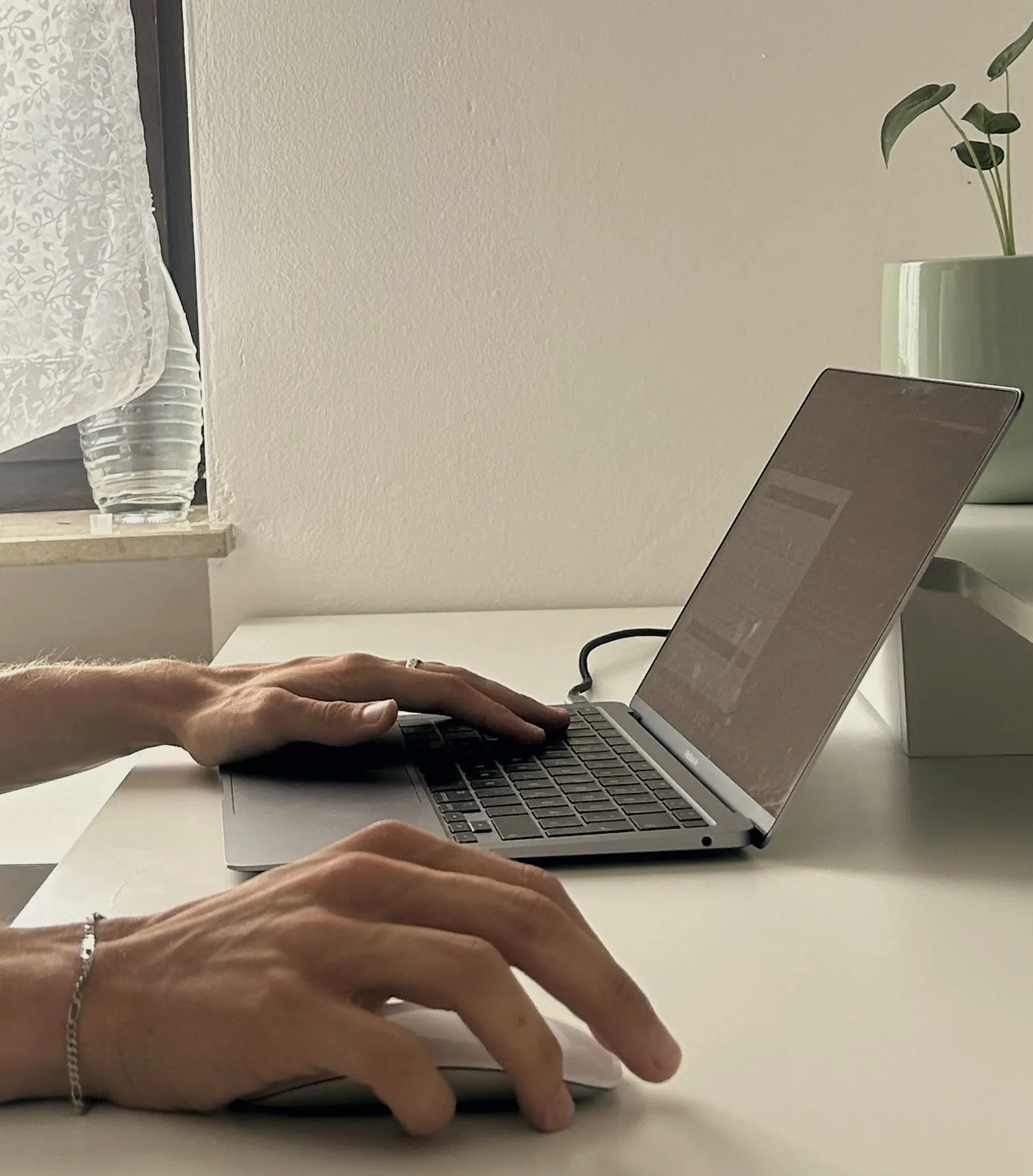 Hände an Laptop-Tastatur und Maus bei der Website-Umsetzung